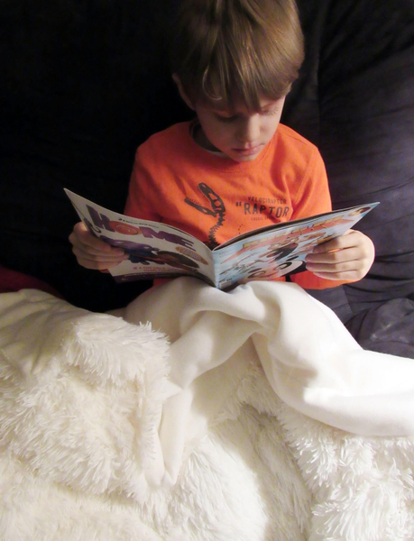 Reading his comic book.